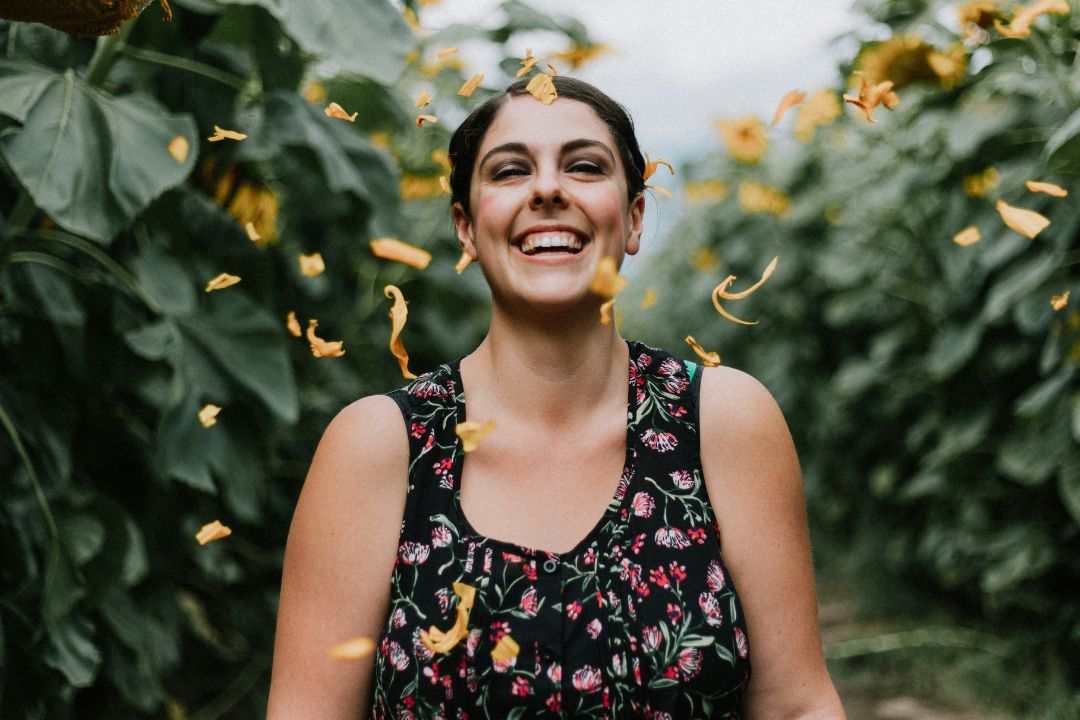 woman smiling with flower petals