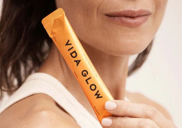 Lady holding a sachet of vida glow marine collagen