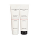 Two white tubes of Percy & Reed London haircare products on a white background: Volumising Shampoo with a pink accent band and Volumising Conditioner with a black flip-top cap.