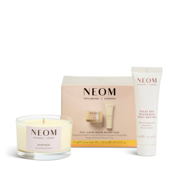 NEOM Welcoming London Feel Good Mood Boost Duo gift set, featuring a 'happiness' scented soy candle, a tube of Great Day Magnesium Body Butter, and the product packaging box.