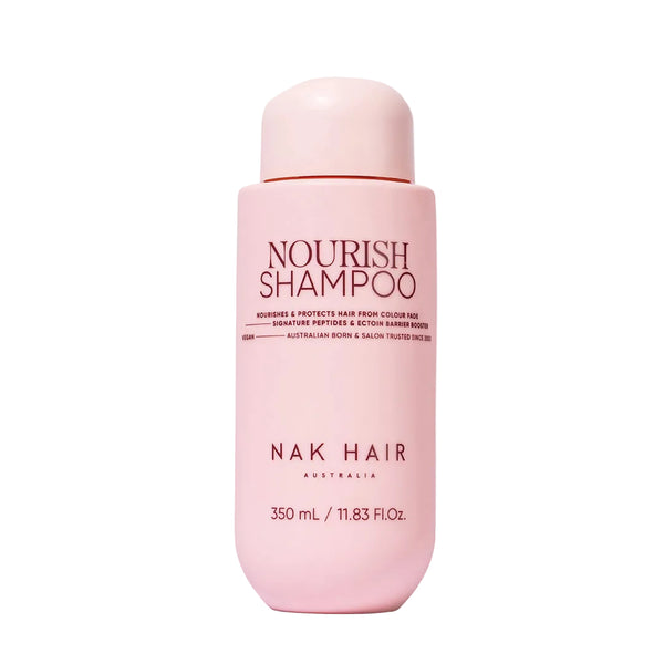 Pink shampoo bottle labeled 'Nourish Shampoo' by NAK Hair on a white background
