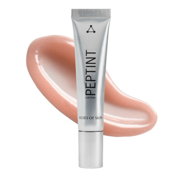 A silver squeeze tube of PEPTINT by Clรฉs de Skin, set against a glossy peach-colored cosmetic swatch on a solid white background.