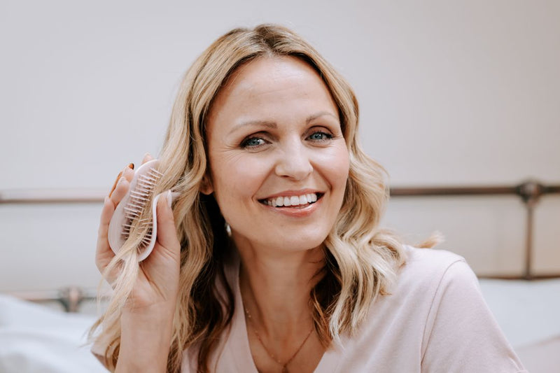 Woman brushing hair with Manta Original hairbrush