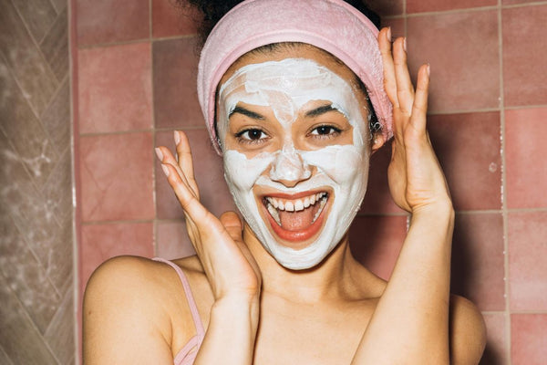 close up of girl smiling and wearing clay face mask