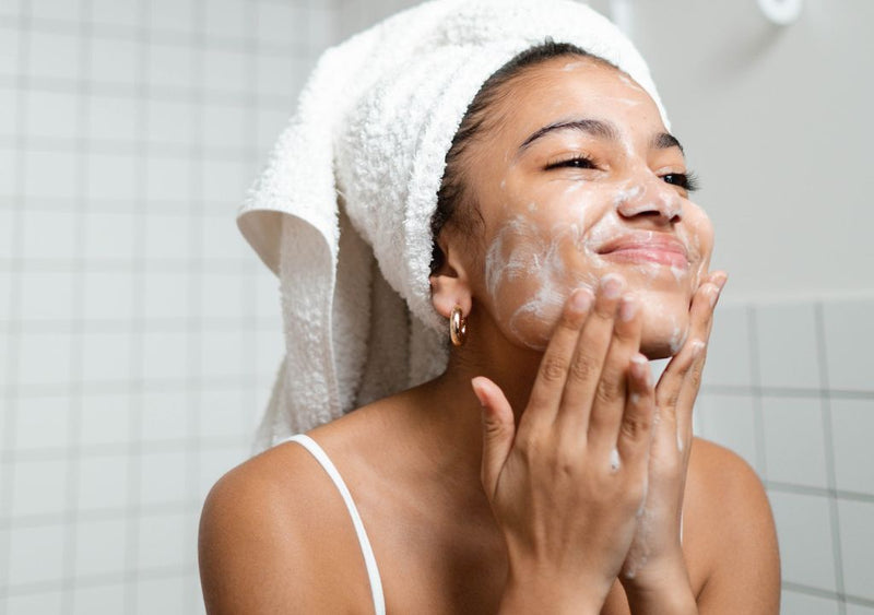 Lady washing her face with cleanser