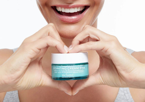 Smiling lady holding Melumé Skinscience Hydrating Serum 8HA