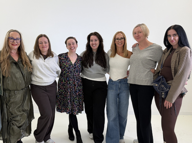 Face the Future customers smiling at the camera in a blank studio