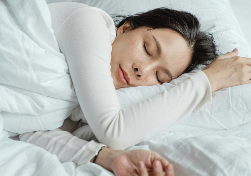 woman laid in bed sleeping getting her beauty sleep