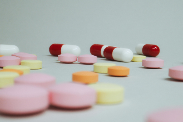 an array of pink, orange, yellow and red and white supplements on a grey background
