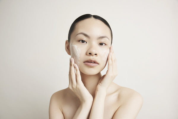 a woman applying Decree Deep Cleanse to her cheek