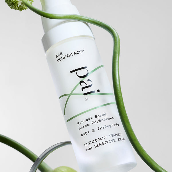 Skincare serum bottle labeled 'pai' with green leaves and a glass container in the background
