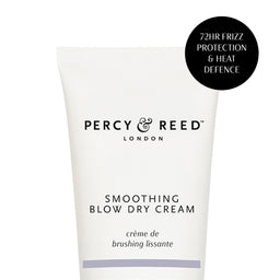 A white squeeze tube of Percy & Reed London Smoothing Blow Dry Cream with black text, featuring a black circular badge on the top right that reads '72HR FRIZZ PROTECTION & HEAT DEFENCE'.