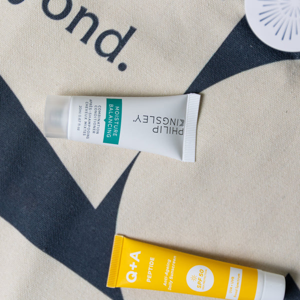 Two skincare products on a patterned fabric background