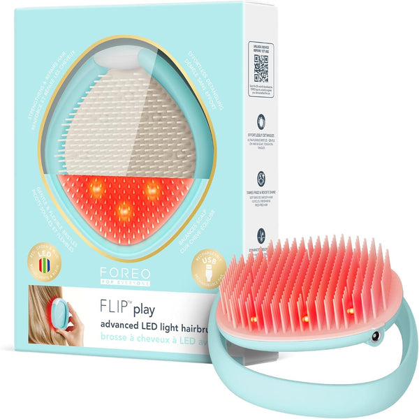 FOREO FLIP play advanced LED light hair brush shown with its light blue retail box on a white background. The brush has a mint blue handle and bristles glowing red from the active LED light therapy, with the packaging displaying the same design.