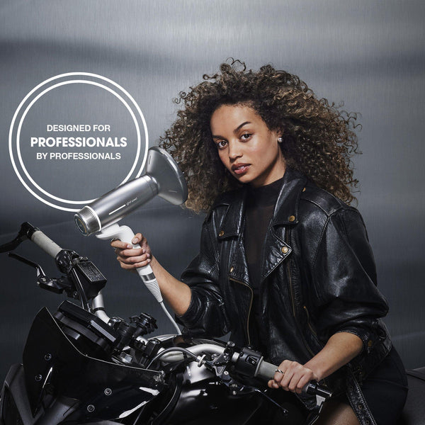 Woman holding a hair dryer with a branded logo on a dark background