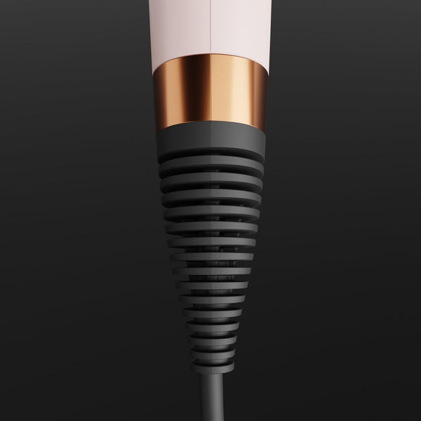 A close-up of a hair dryer nozzle attachment with a matte black ribbed cone, a metallic rose gold collar, and a white barrel, set against a dark gray gradient background.