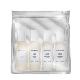 A clear zip pouch containing four small white bottles of Sacha Juan haircare products, photographed on a clean white background.