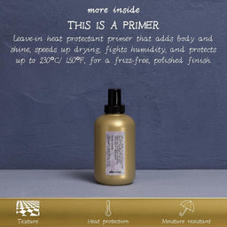 A bottle of d'Kuhnes hair primer centered on a gray surface against a textured blue-gray background, with white descriptive text above and a gold banner at the bottom highlighting texture, heat protection, and moisture resistance.