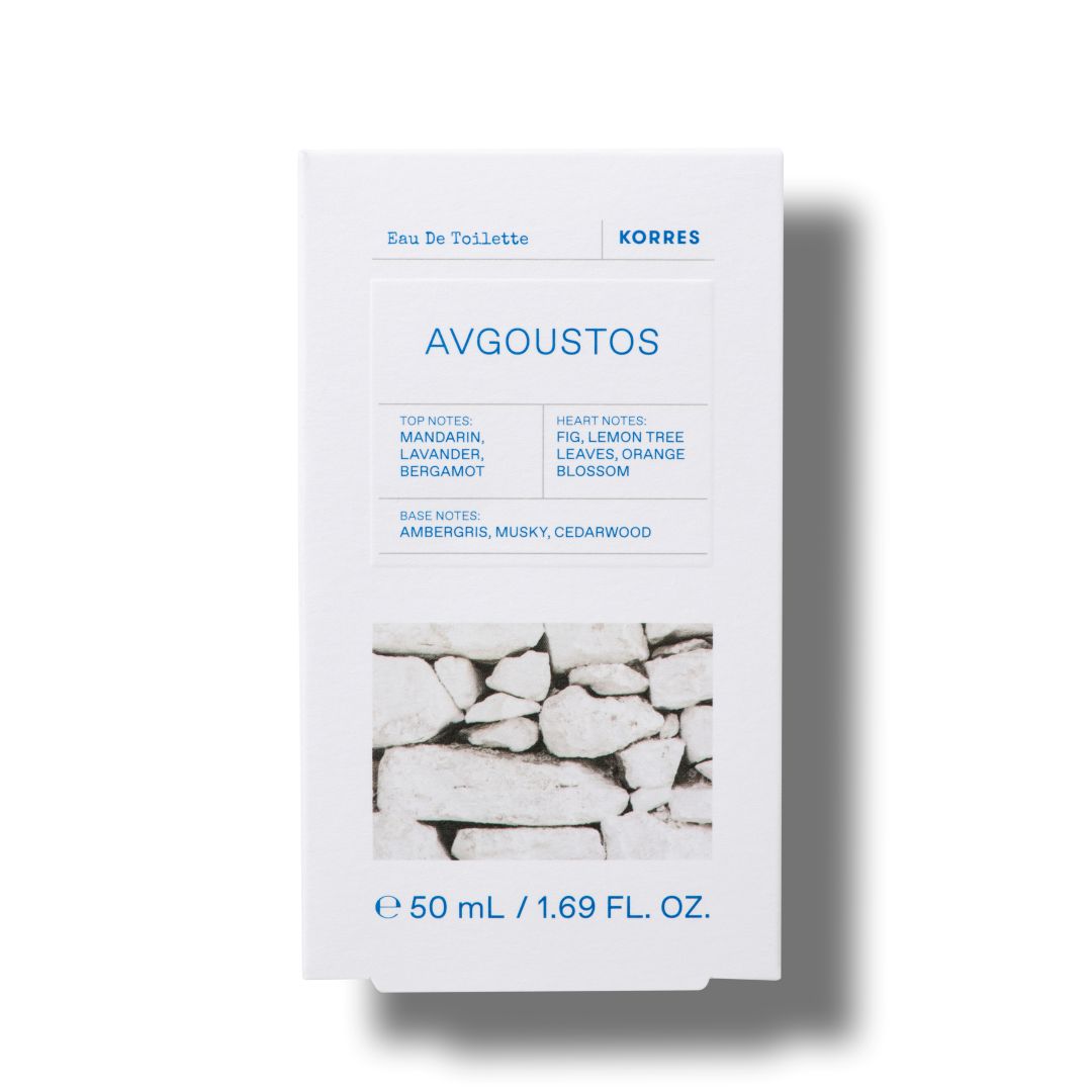 A white rectangular box of KORRES Avgoustos Eau De Toilette, featuring blue text and a black-and-white photograph of stacked stone walls near the bottom, set against a plain white background with a soft drop shadow.