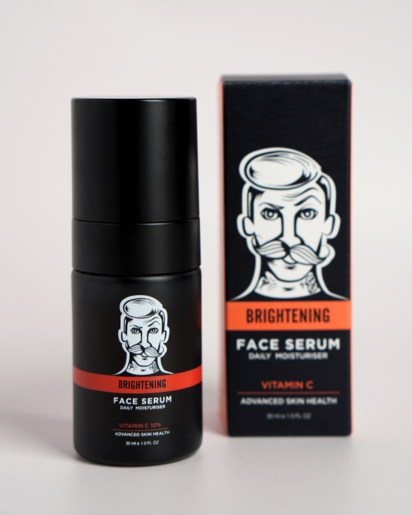 Black face serum bottle with red label and matching box on a light gray background