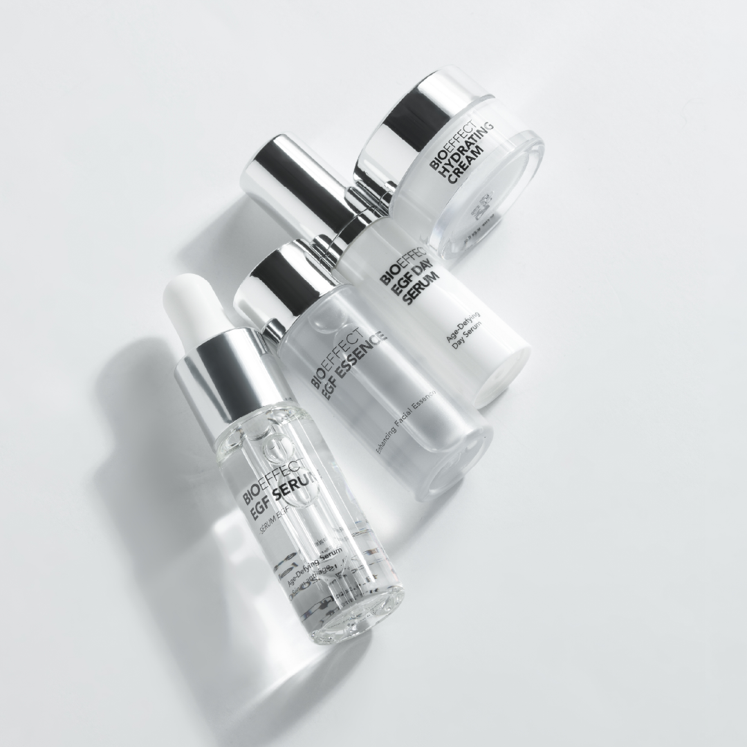 Skincare products including bottles and a tube on a light gray background