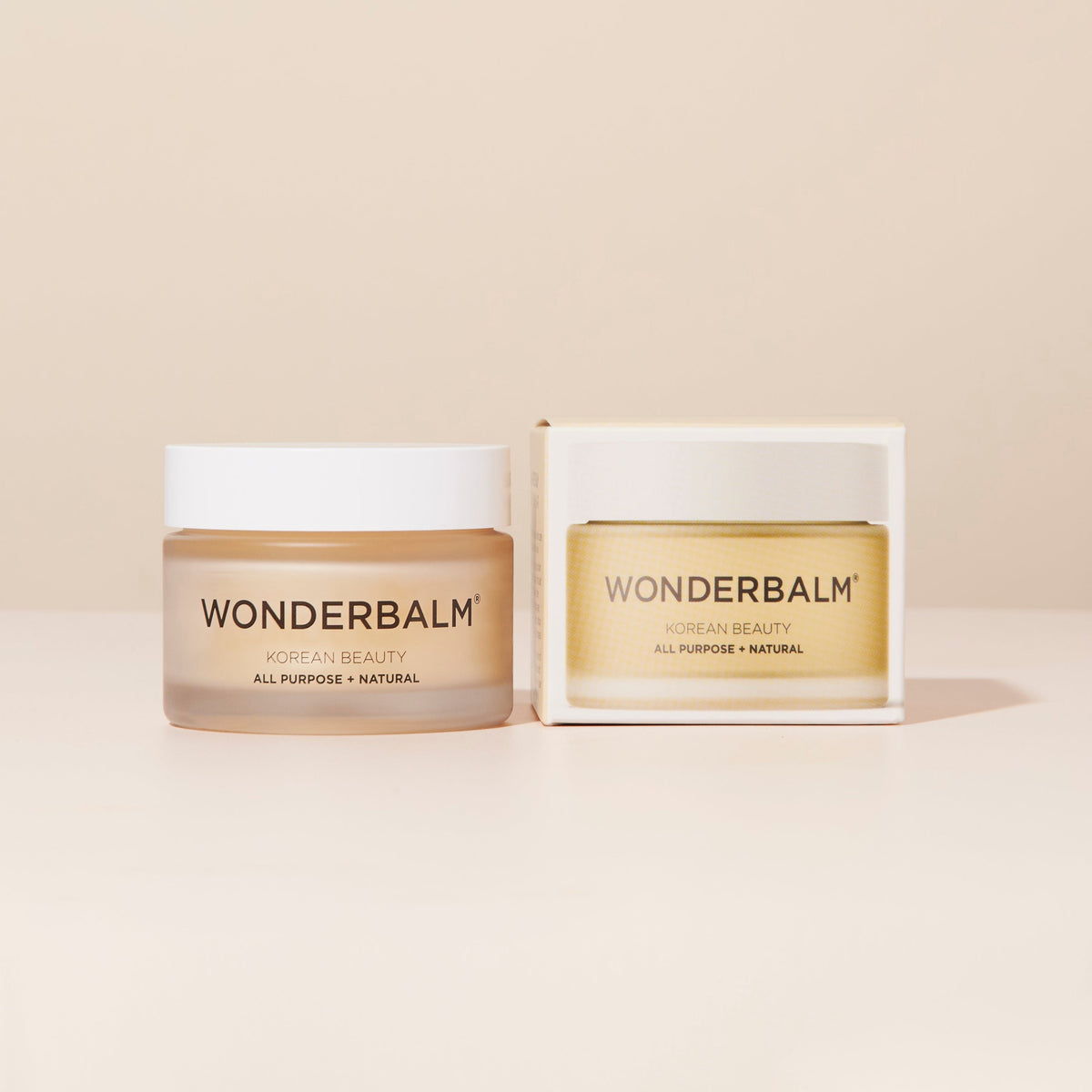 Two jars of Wonderbalm on a beige background