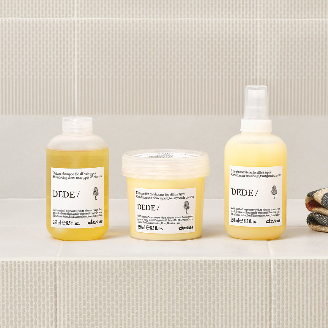 Three bottles of Dede hair care products on a bathroom shelf.