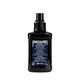 A black bottle of Davines Heart of Glass Sheer Glaze with a matching black spray nozzle, featuring a navy blue label with white text and floral borders, set against a plain white background.
