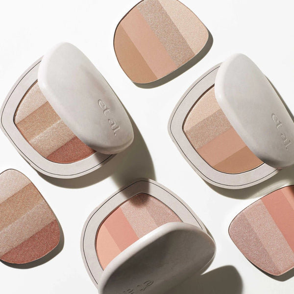 Makeup products with shades of beige, brown, and pink on a white background