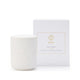 White candle with ribbed texture next to its packaging box on a white background