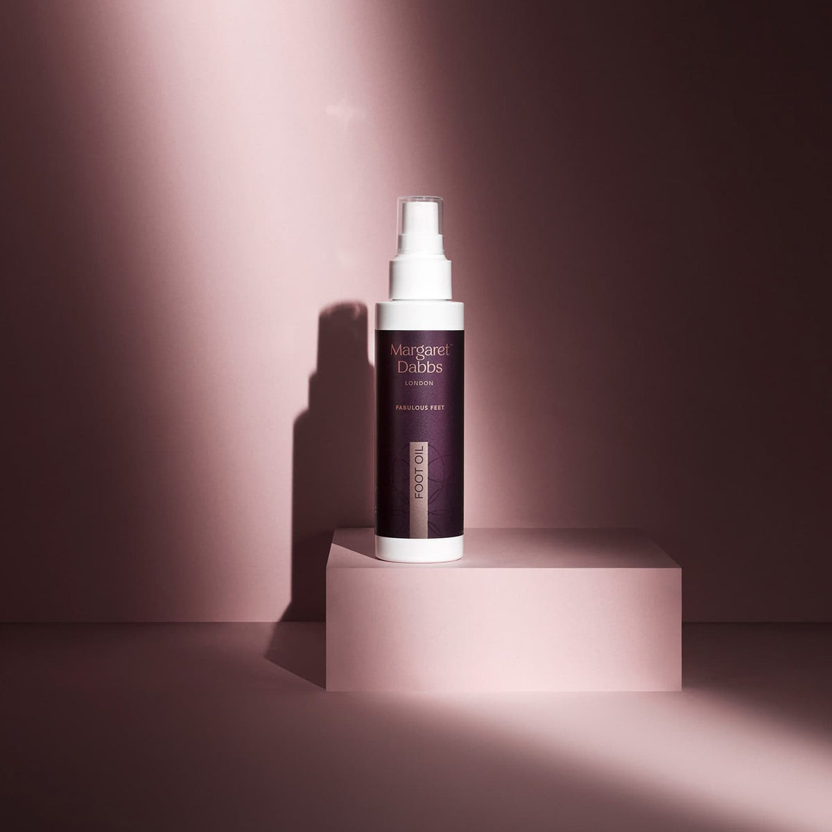 Skincare bottle on a pink platform with a soft pink background