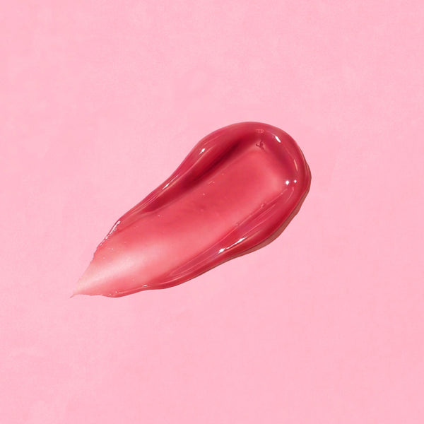 Pink lip gloss swatch on a pink background