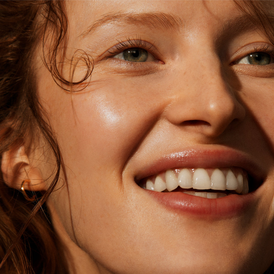 Close-up of a woman's face with a warm, sunlit glow.