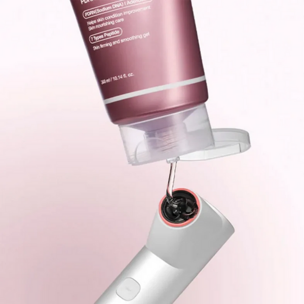 Close-up of a skincare device with a pink container on a light pink background