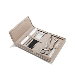 Manicure set with tools in a beige case on a white background