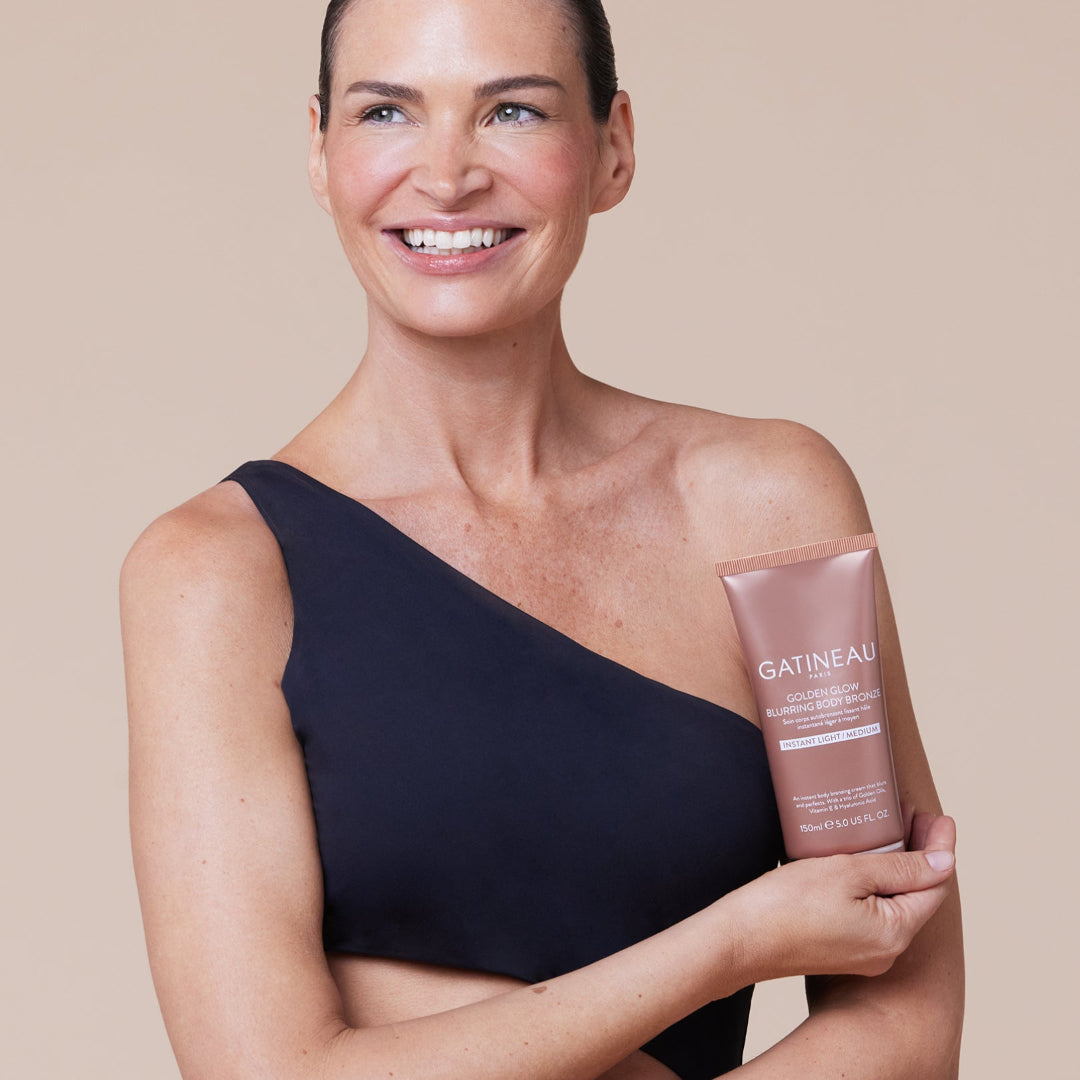 Woman holding a Gatineau product against a beige background