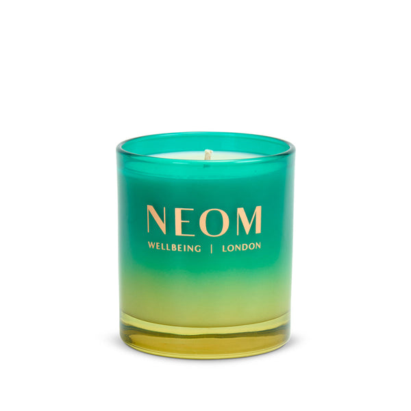 Neom candle with gradient green and yellow design on a white background