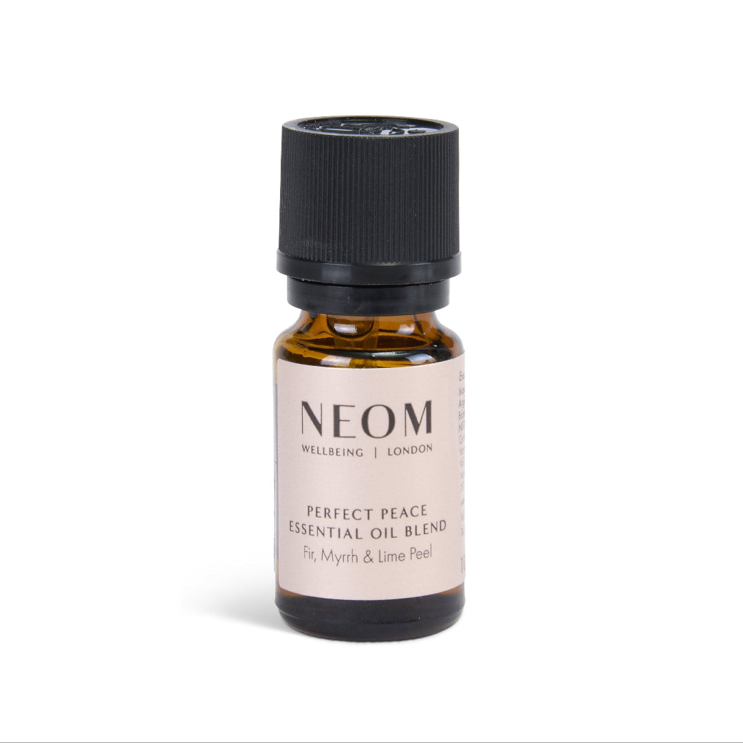 A small amber glass bottle of NEOM Wellbeing London 'Perfect Peace' essential oil blend with a black ribbed cap and a beige label, centered on a white background.