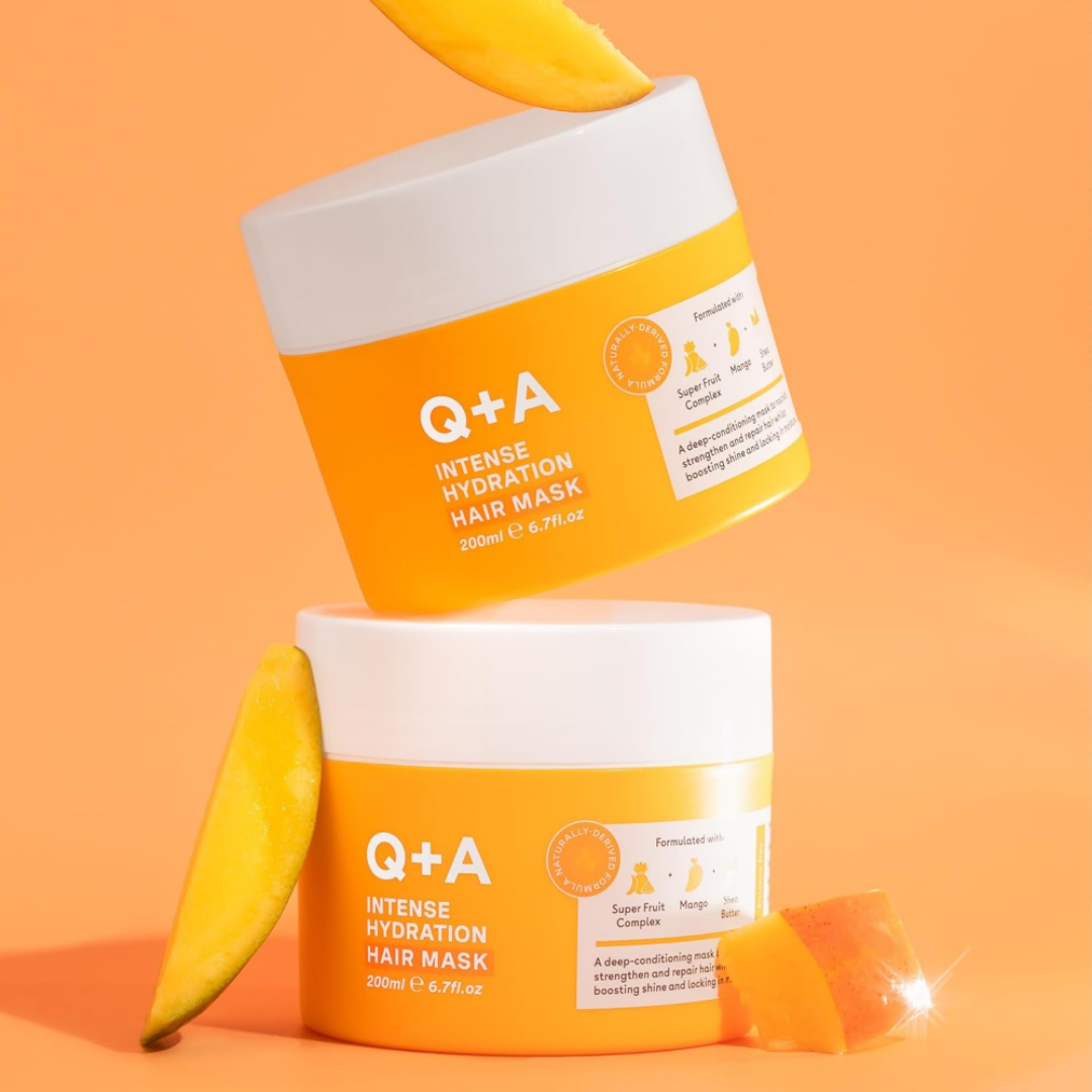 Two jars of Q+A Intense Hydration Hair Mask with bananas on an orange background