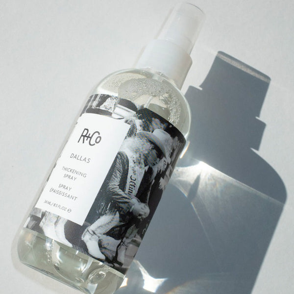 a closeup of the R+Co Dallas Thickening Spray bottle