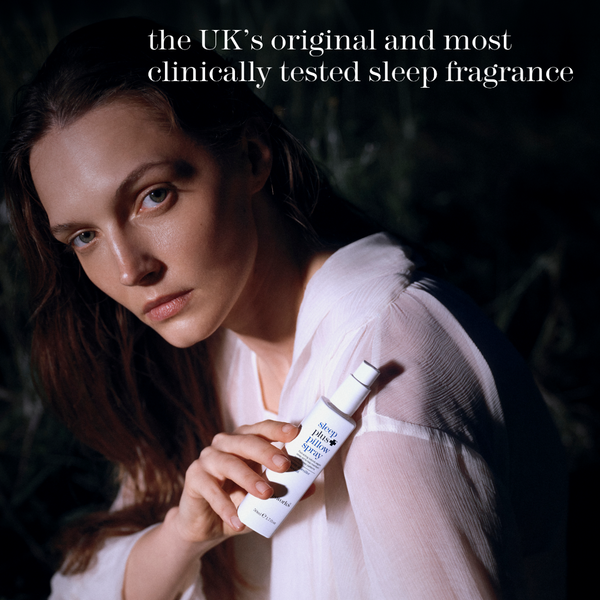 A woman in a white top holds a bottle of sleep fragrance against a dark, moody background. White text at the top reads, 'the UK's original and most clinically tested sleep fragrance.