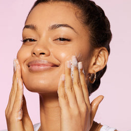 a model applying the cleanser to her face