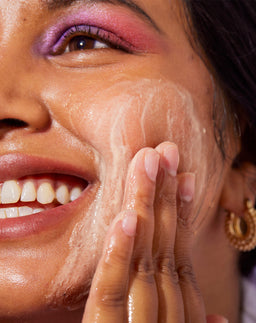 Model applying Sand & Sky Australian Pink Clay Deep Pore Cleanser to her face