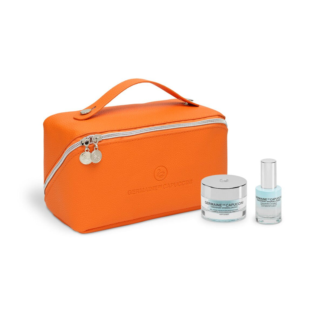 Orange travel bag with skincare products on a white background
