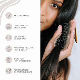 A close-up of a woman holding a dark brown hairbrush against her long black hair, with a text panel on the left listing benefits such as anti-breakage, ultra-gentle detangling, use on wet or dry hair, healthy hair and scalp support, ideal for hair extensions, and trichologist recommendation.