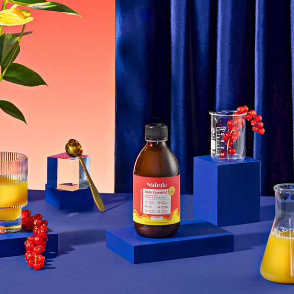 Bottle of Valerian Root Tonic on a blue platform with a colorful background