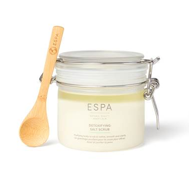 Jar of ESPA salt scrub with a wooden spoon on a white background