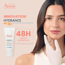 Avene Hydrance SPF 30 moisturizing cream with a woman applying it on her face.