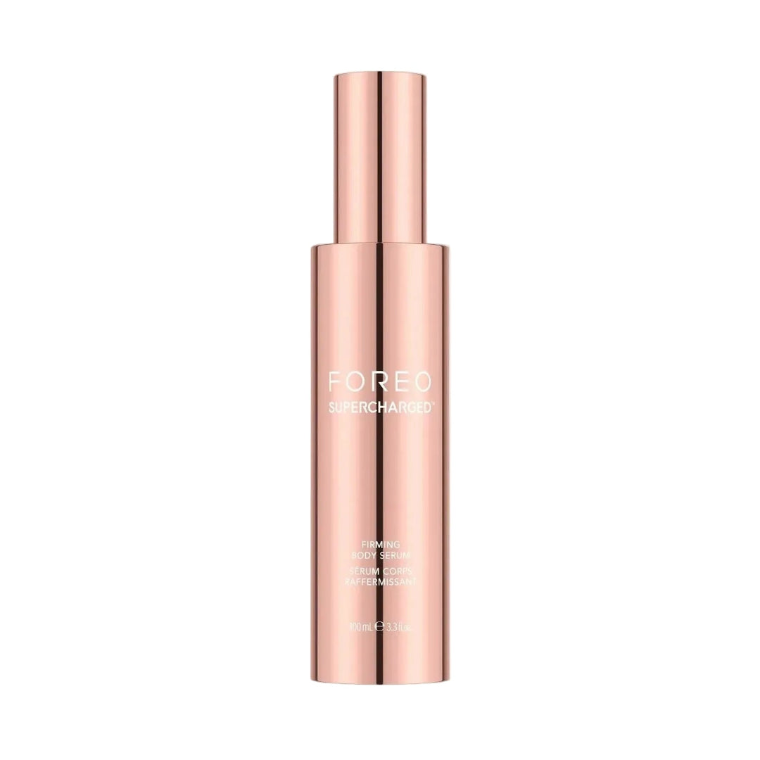 A sleek, metallic rose gold cosmetic bottle with a matching cylindrical cap, featuring the brand name 'FOREO' and product name 'EAR PIERCING' printed in white on the front, set against a solid off-white background.