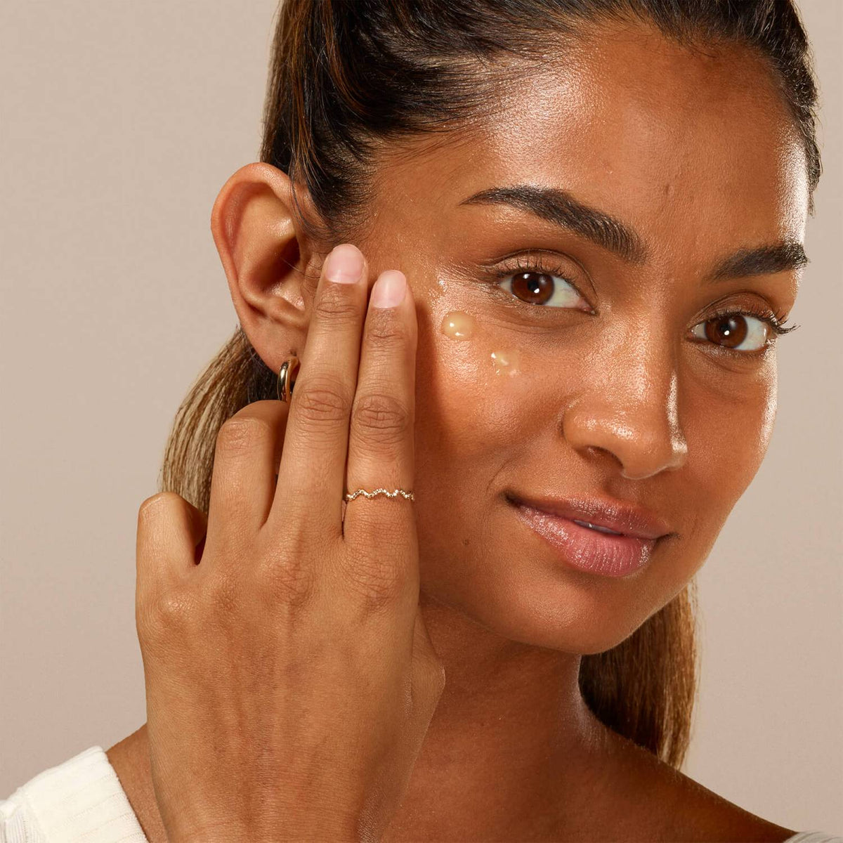 a women applying serum to her face
